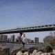 Uma criança brinca nas rochas sob a ponte de Manhattan no bairro de Brooklyn em Nova Iorque, EUA – CARLO ALLEGRI/REUTERS